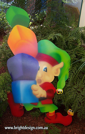 4- E-33 Unbalanced Christmas Presents Elf Outdoor Christmas Cut Out in a Garden Christmas Display
